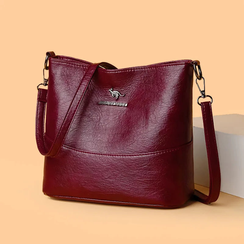 Women's soft leather bucket shoulder bag in solid colour with sewing line details and organisational pockets