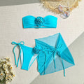Women's pink swimsuit set with 3D flower tube top, high-waisted bottoms, and separate tie-front skirt laid flat.