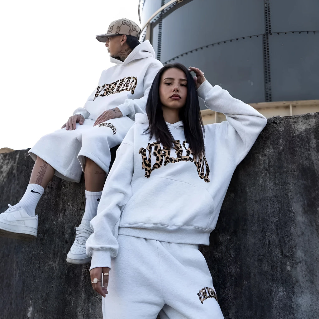 Men's patchwork loose trousers with a double waistband and zip fly, shown in streetwear style.