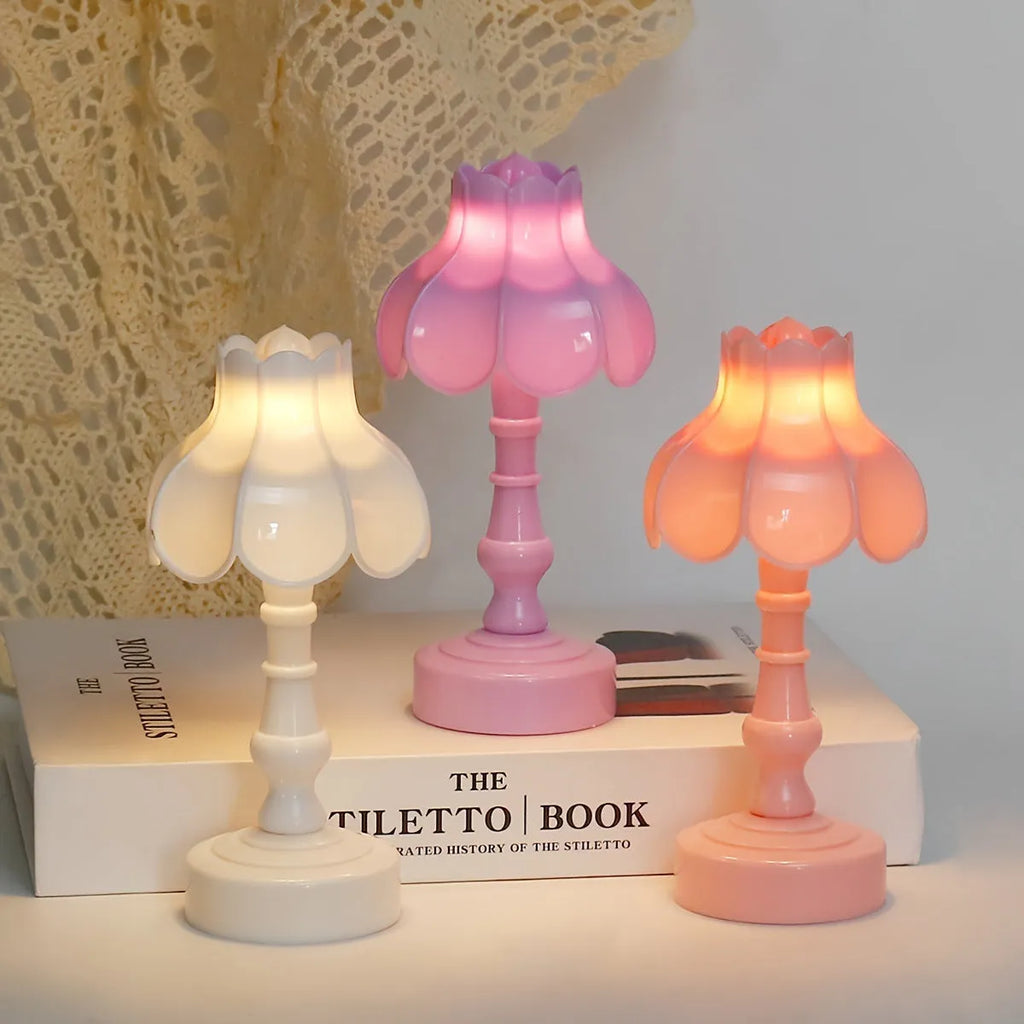 Small geometric retro pagoda night lamp in light purple, shown on a wooden surface.