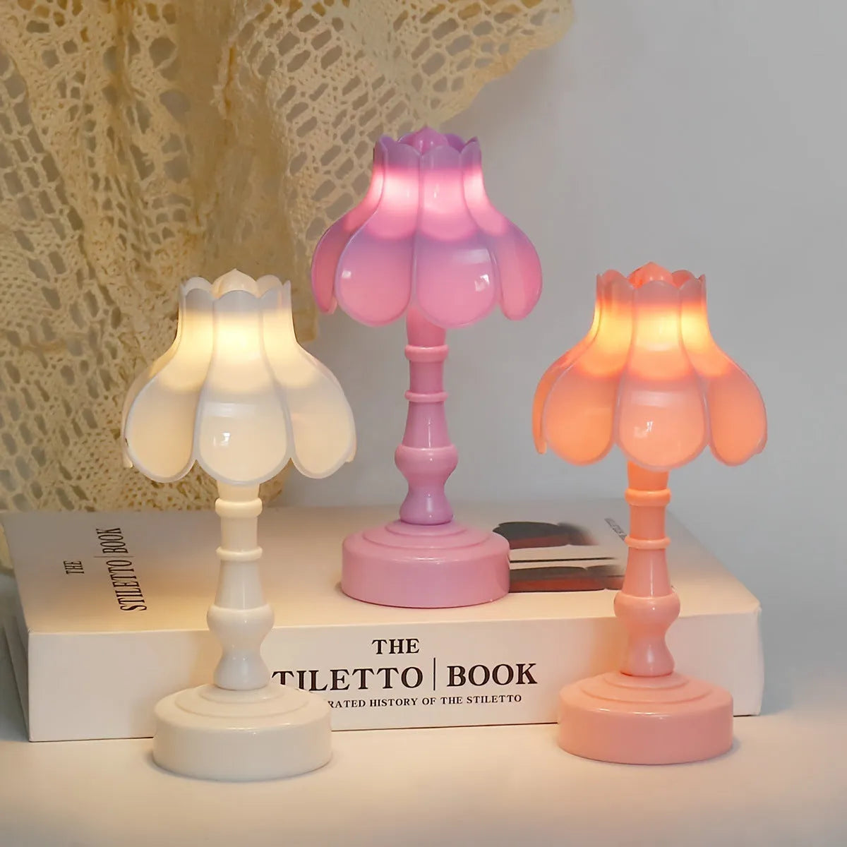 Small geometric retro pagoda night lamp in light purple, shown on a wooden surface.