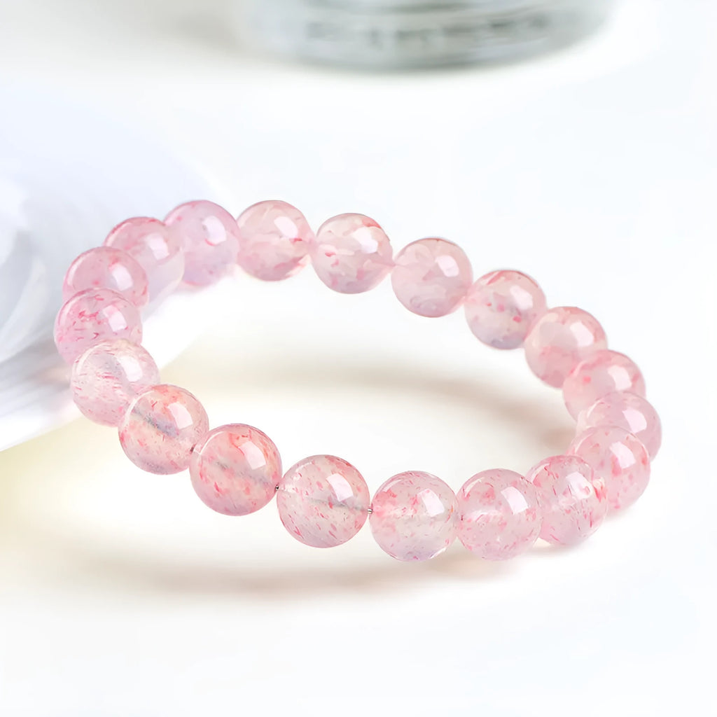 Geometric strawberry quartz crystal beads bracelet in natural white water colour on a wrist.