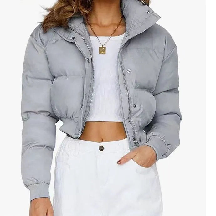 A woman's loose-fitting blue polyester casual jacket with long sleeves on a hanger.