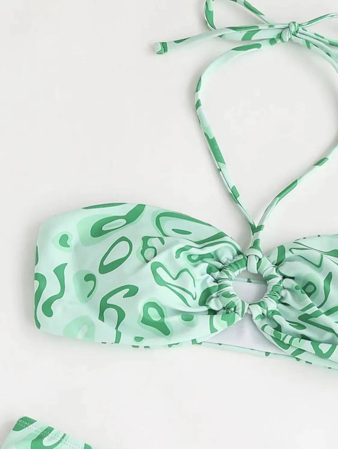 Green floral bandeau bikini swimsuit with split design and adjustable straps on mannequin