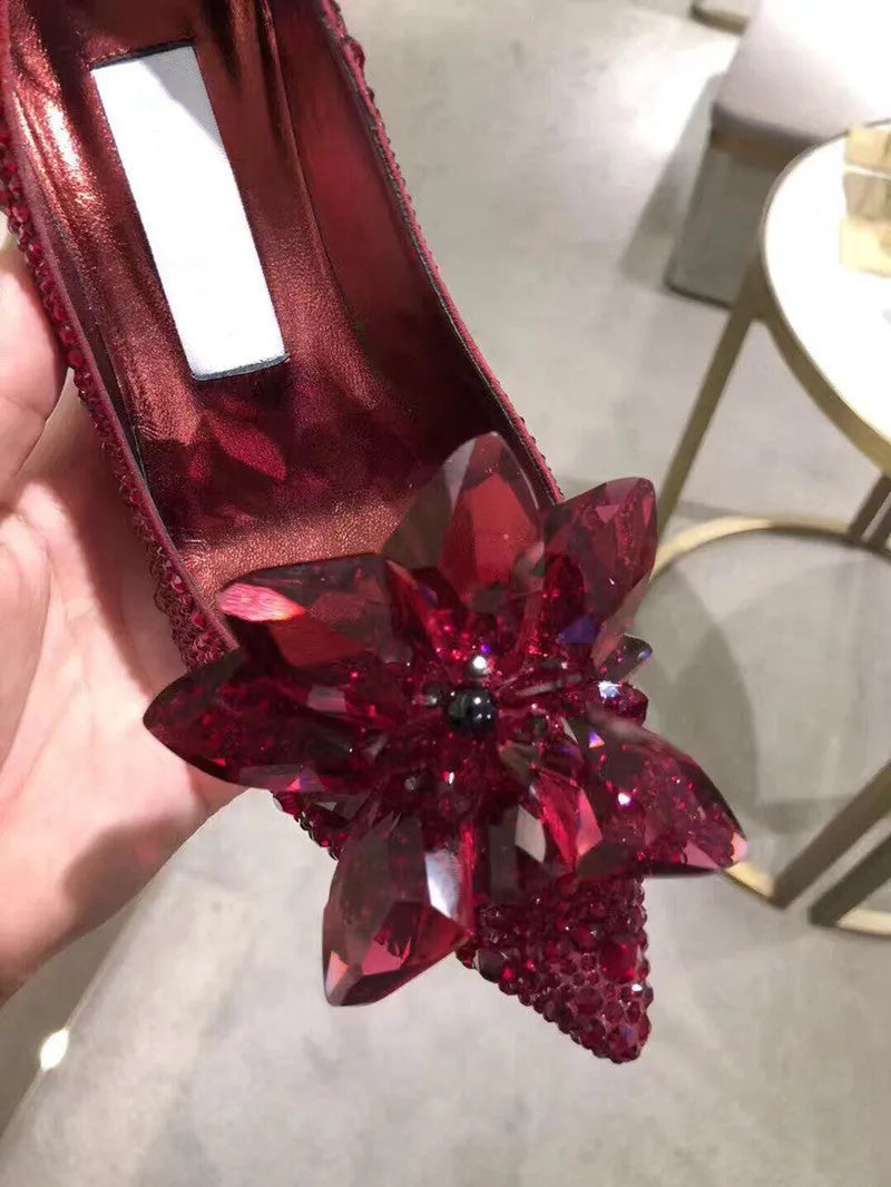 Gold women's stiletto heels with sequin upper, rhinestones, a bow, and a pointed toe.
