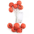 Halloween pumpkin string lights with warm white LEDs and iron pendants on a dark background