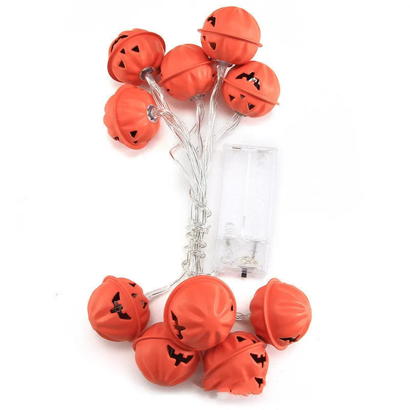 Halloween pumpkin string lights with warm white LEDs and iron pendants on a dark background
