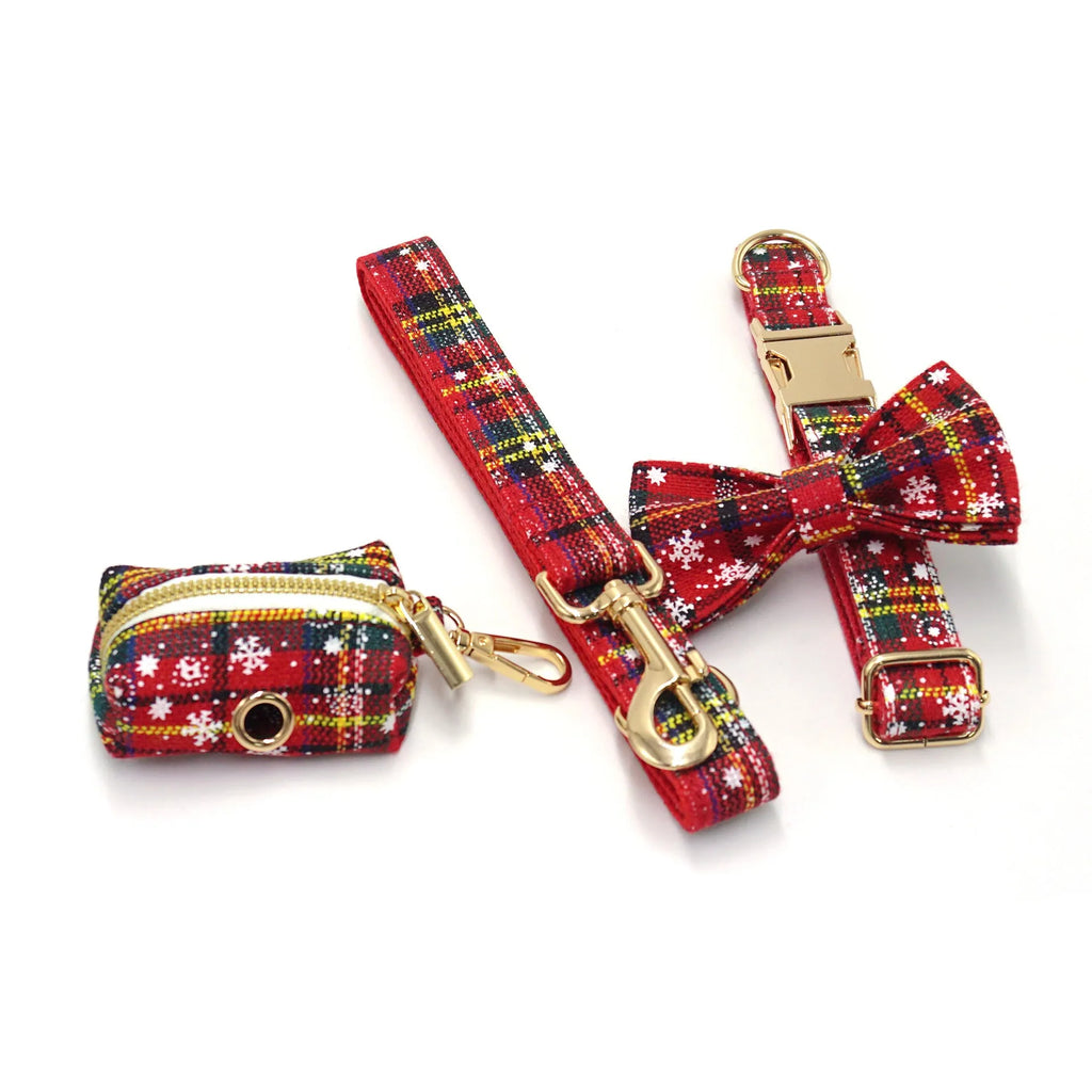 Red Christmas pet collar set with matching harness, leash, bow, and dog waste bag on cloth background