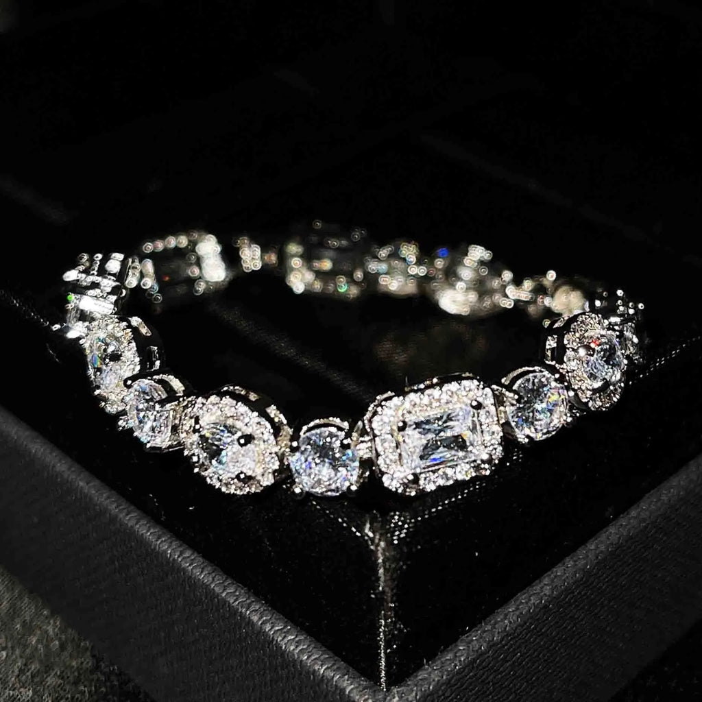 Close-up of women's geometric silver bracelet with inlaid zircon stones on a wrist, showing adjustable chain links.