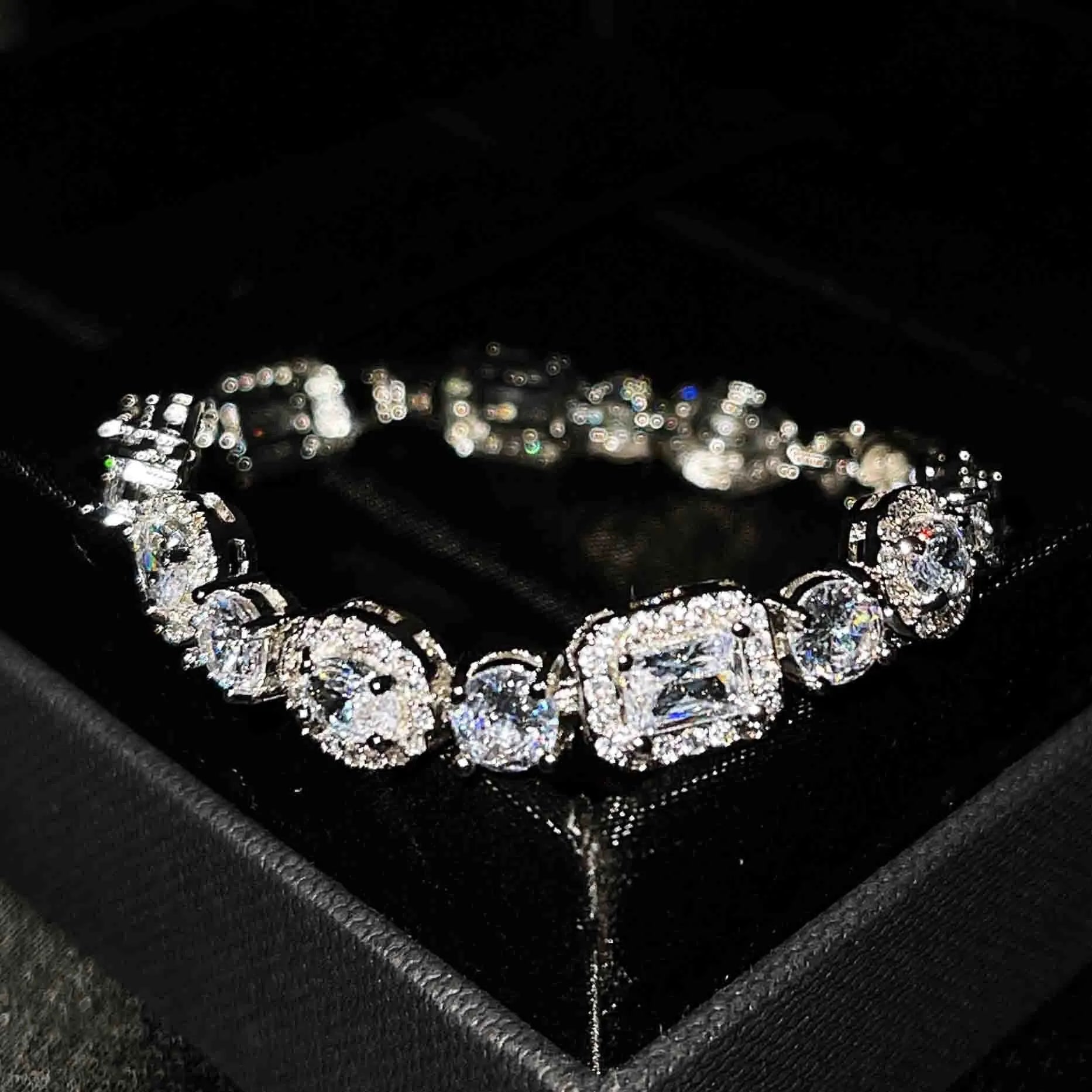 Close-up of women's geometric silver bracelet with inlaid zircon stones on a wrist, showing adjustable chain links.