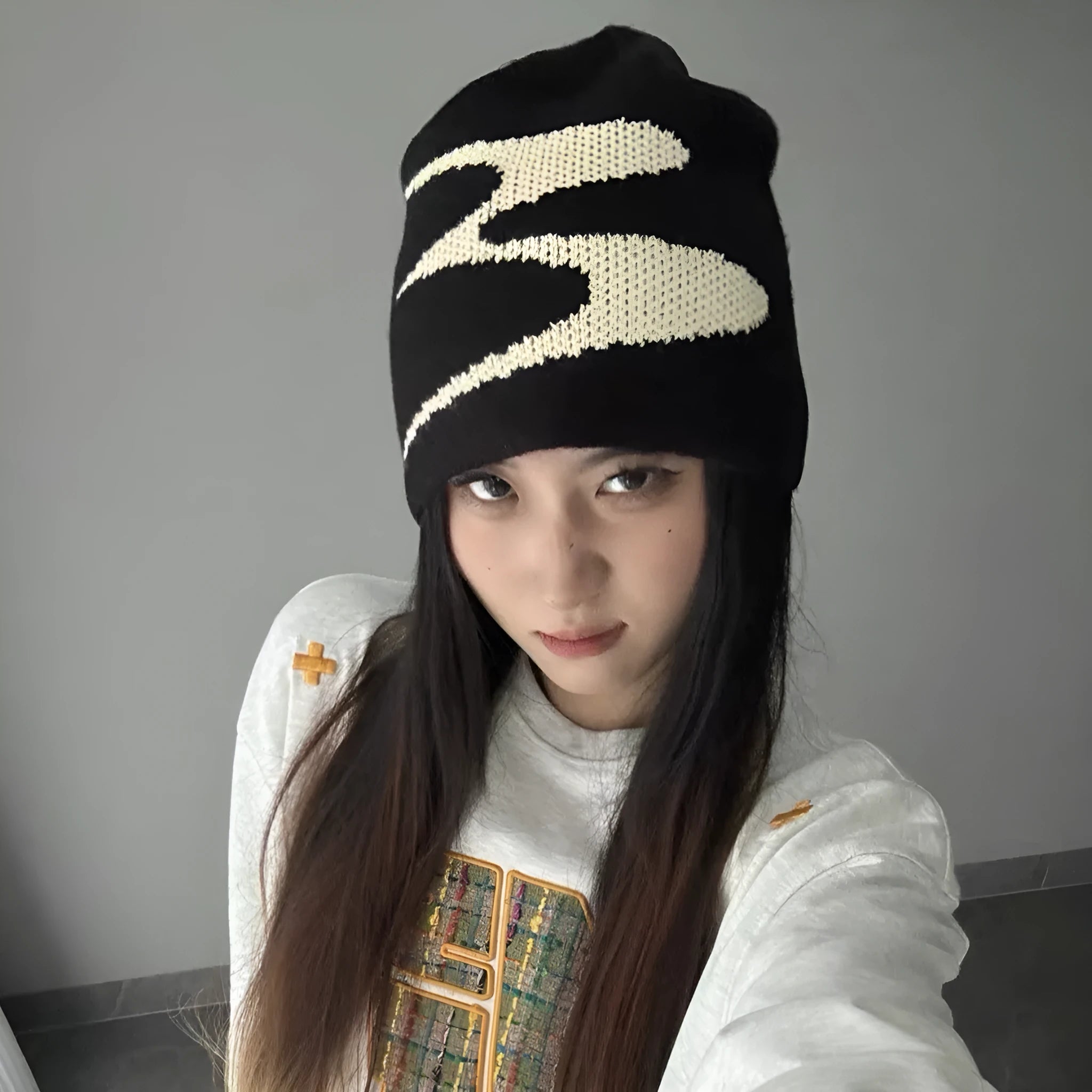 A knitted acrylic beanie hat in black, shown on a model, for autumn and winter wear.