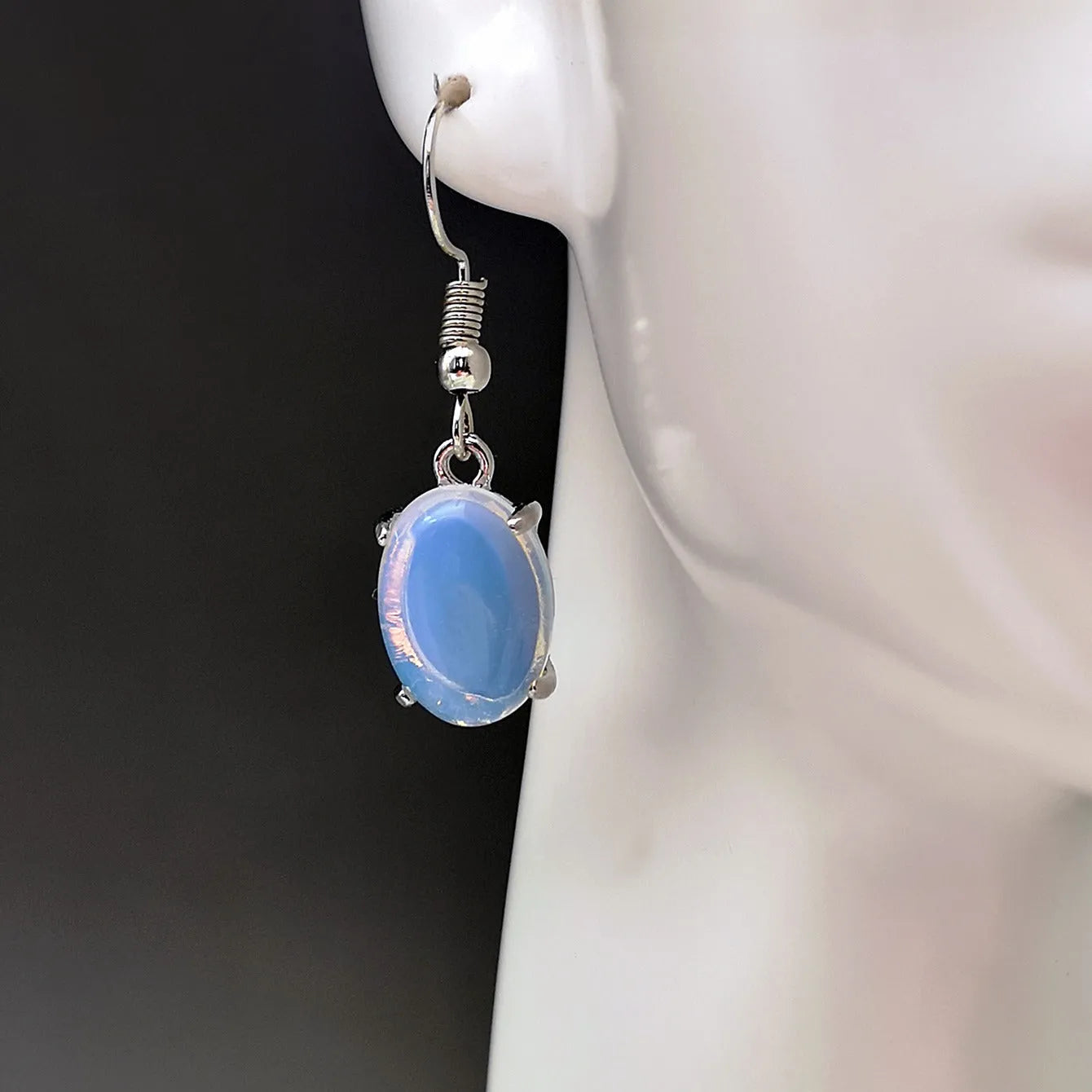 Pair of retro-style drop earrings with a moonlight opal colour and cross detail on an alloy base.