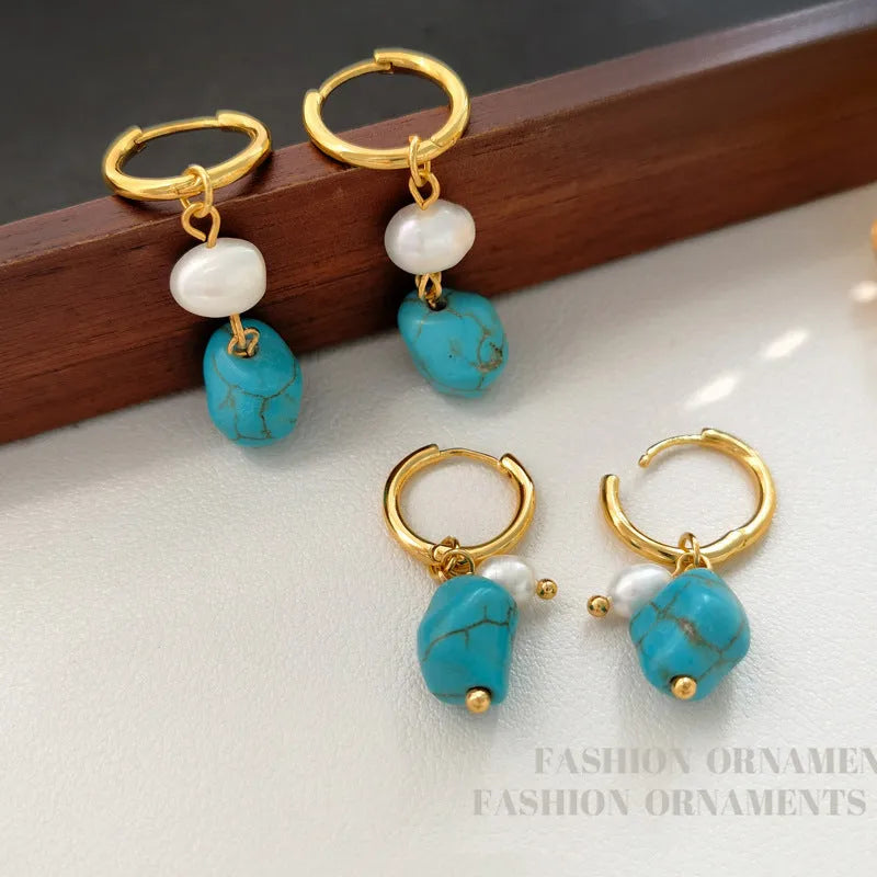 A pair of geometric copper earring clips with turquoise stones and cultured pearls, one short and one long.