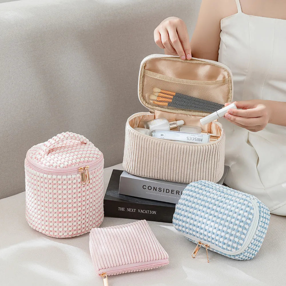Set of four cube-shaped pink flannelette makeup bags with zips, one showing a removable interior divider and a metal hook.