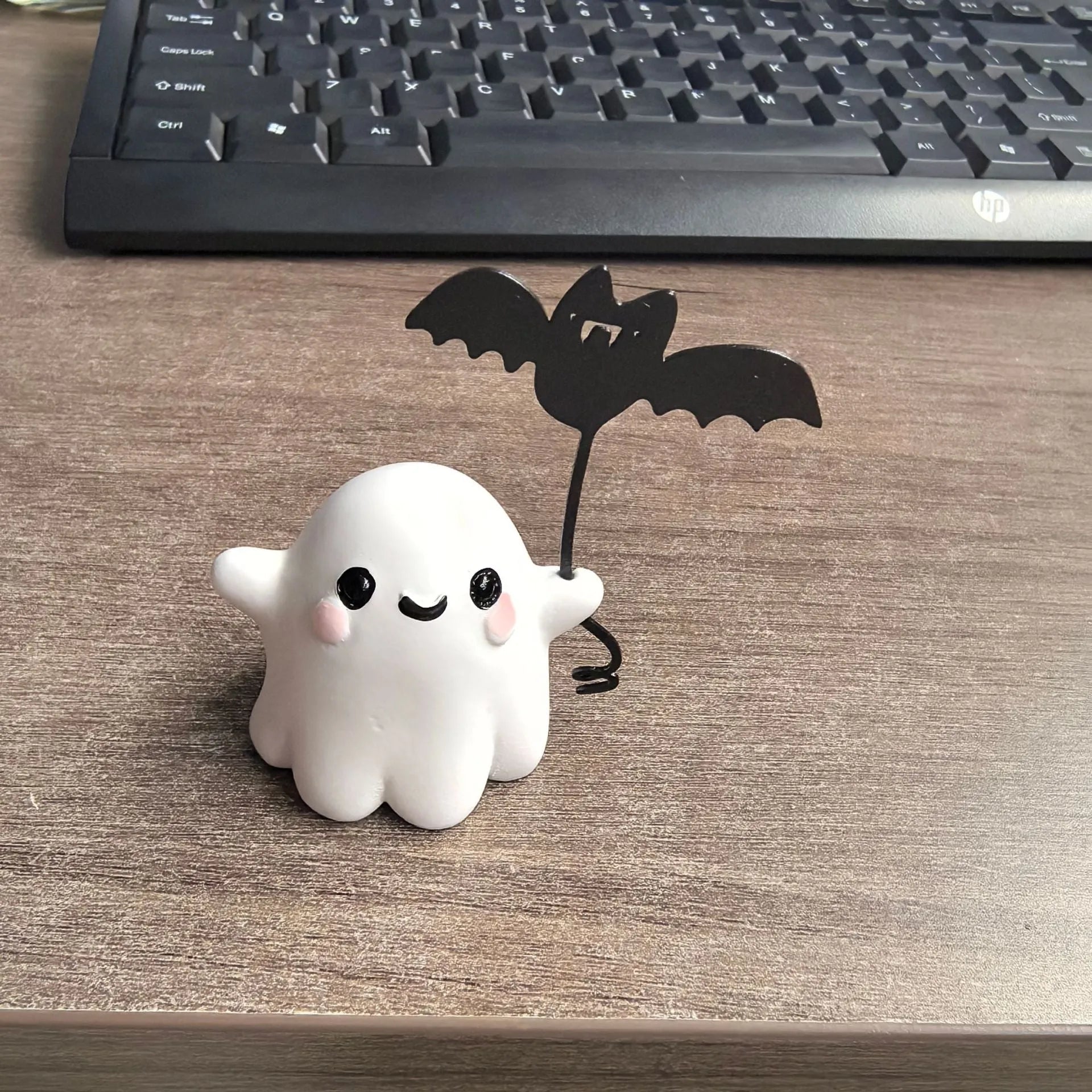 Miniature white ghost dog walking statue holding a small black bat, resin Halloween ornament