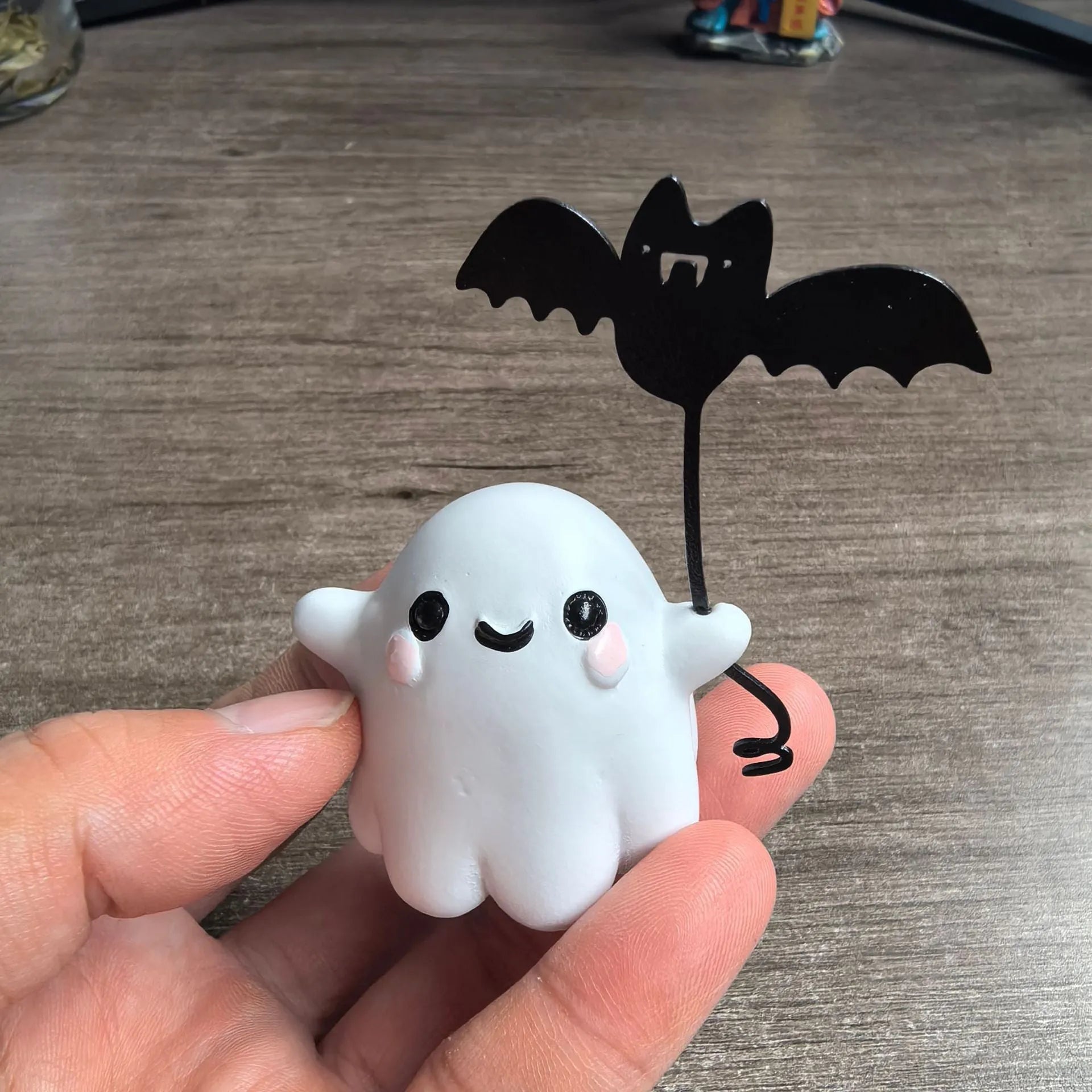 Miniature white ghost dog walking statue holding a small black bat, resin Halloween ornament