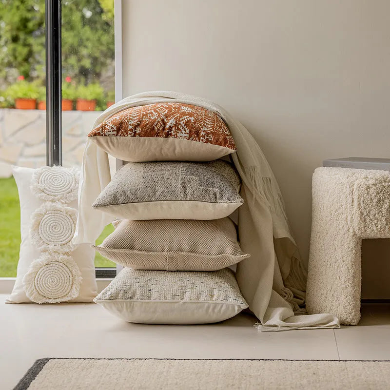 A square solid-colour cushion pillow on a sofa, showing its plain edge detail.