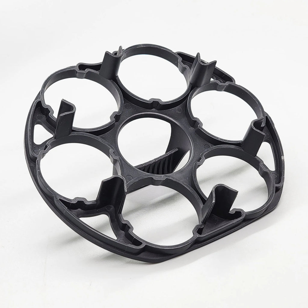 Black plastic egg holder cooking basket rack with retainer on a kitchen counter.