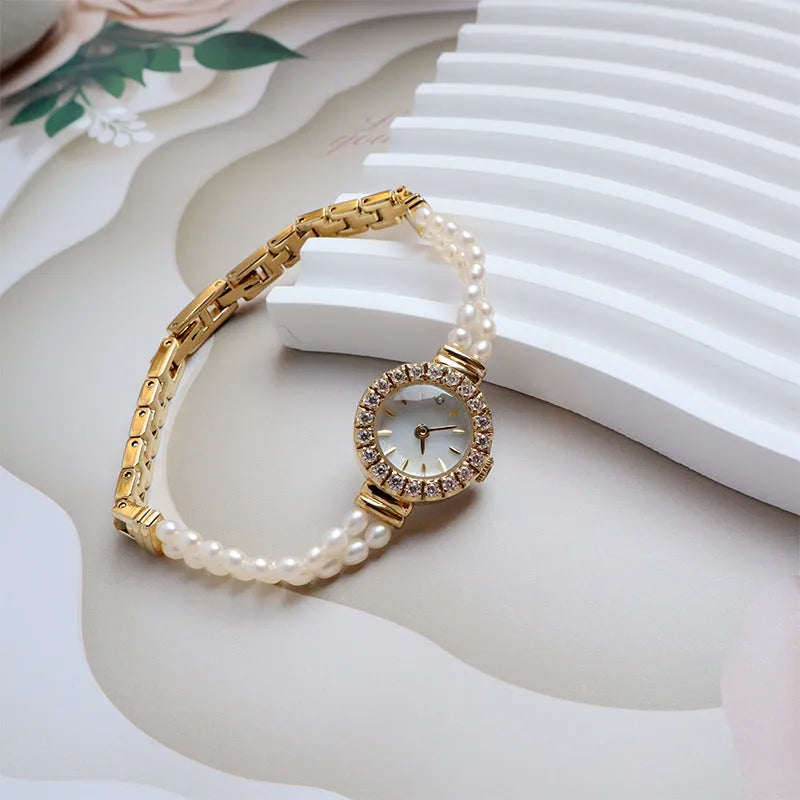 Light gold women's freshwater pearl bracelet watch with round dial on stainless steel strap.
