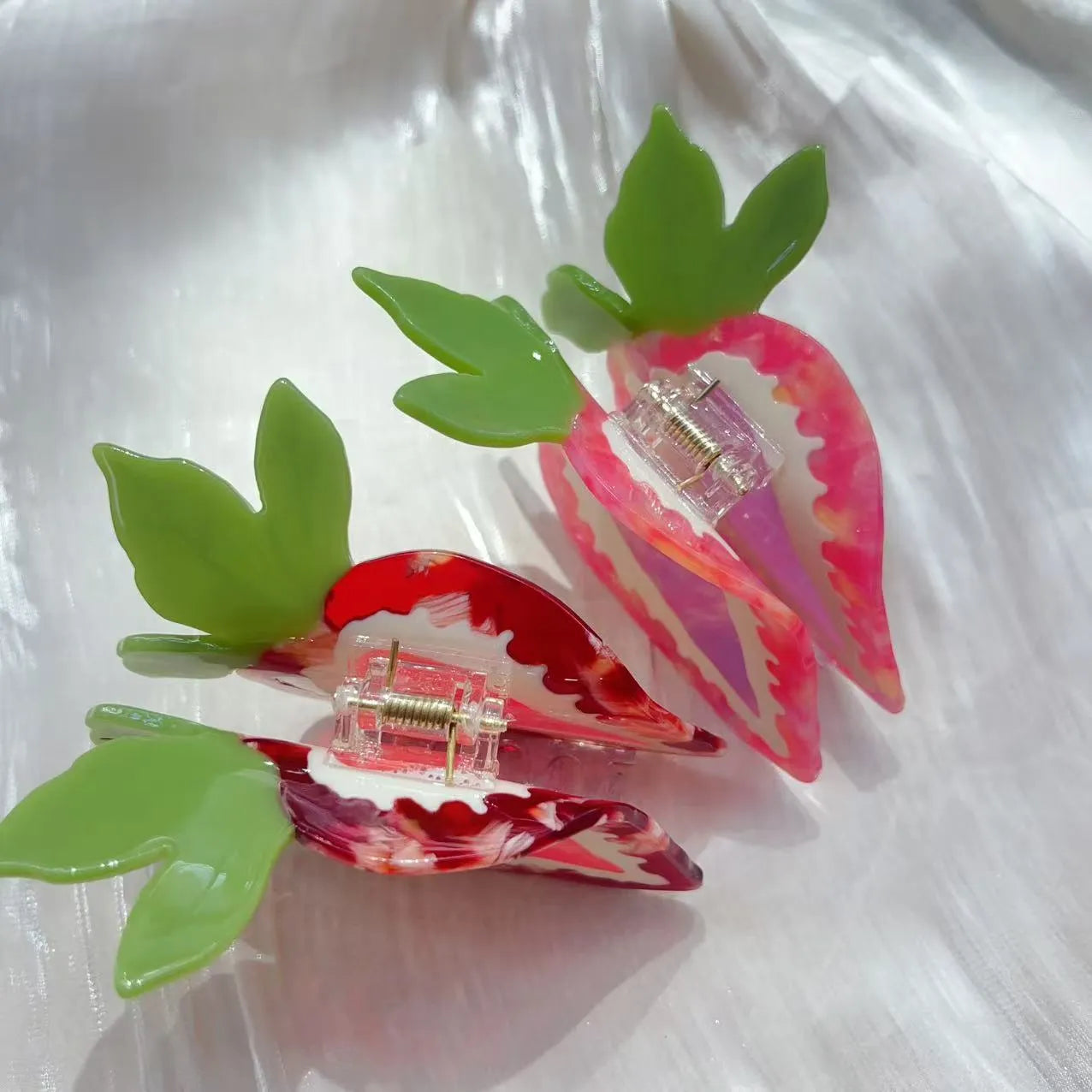 Handmade red and pink strawberry hairpin for girls on a white background.
