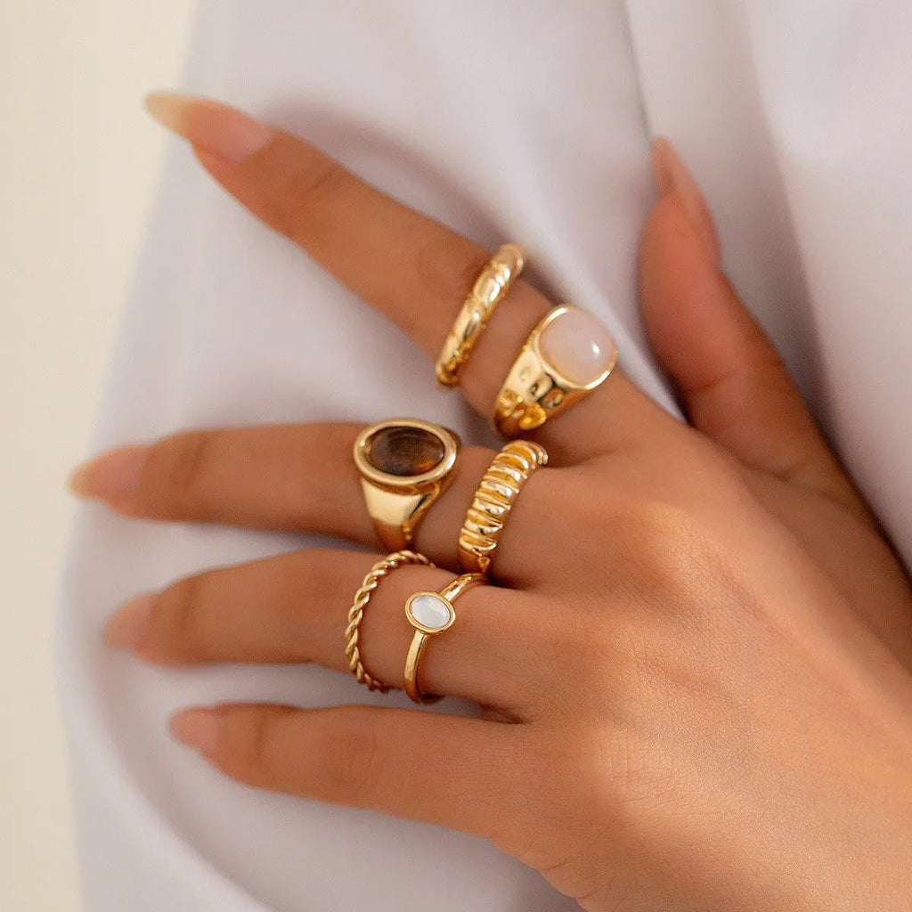Six geometric irregular shaped alloy rings in light gold electroplated finish displayed together