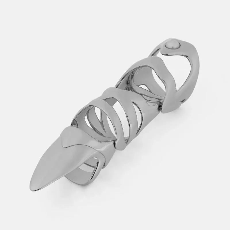Silver-coloured metal finger cover with punk armour design shown on a model's finger.