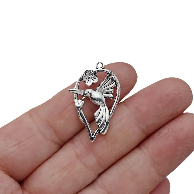 Gold tone alloy pendant with a detailed cast magpie design, shown from the front and back.