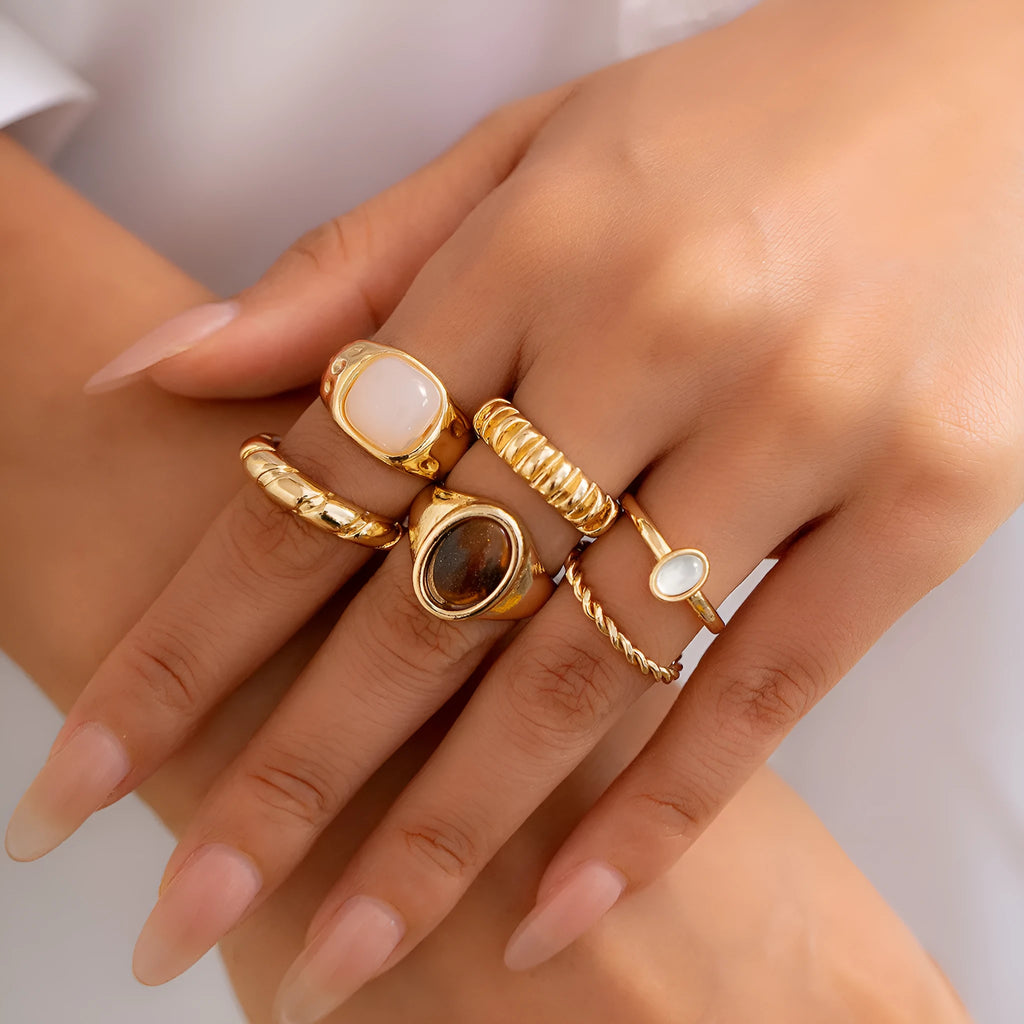 Six geometric irregular shaped alloy rings in light gold electroplated finish displayed together