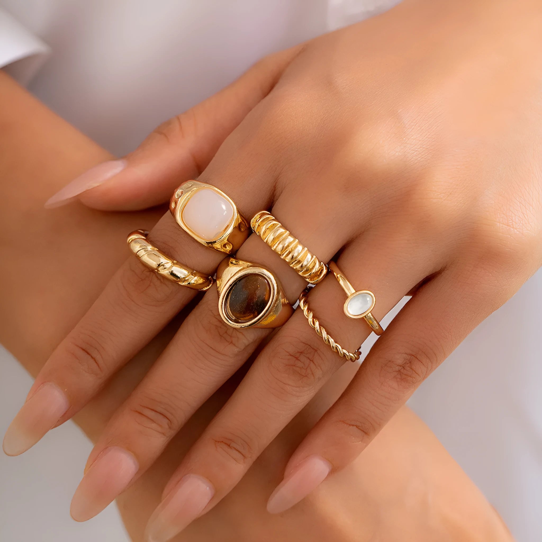 Six geometric irregular shaped alloy rings in light gold electroplated finish displayed together