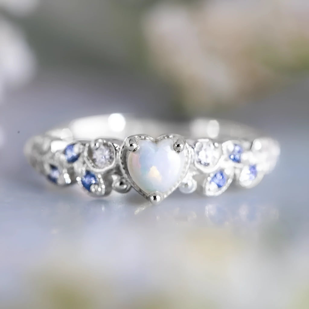 Silver-colour alloy ring with a peach heart centre and a floral opal stone detail.