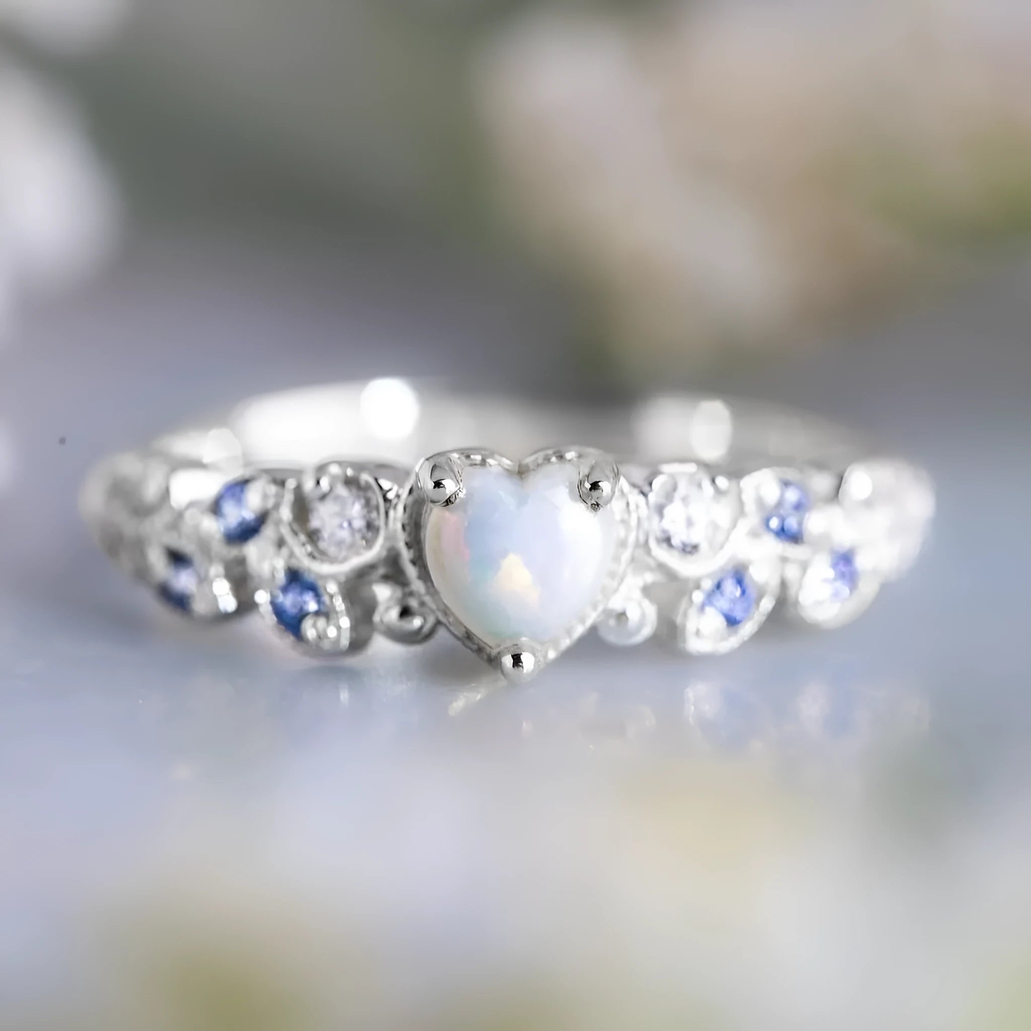 Silver-colour alloy ring with a peach heart centre and a floral opal stone detail.