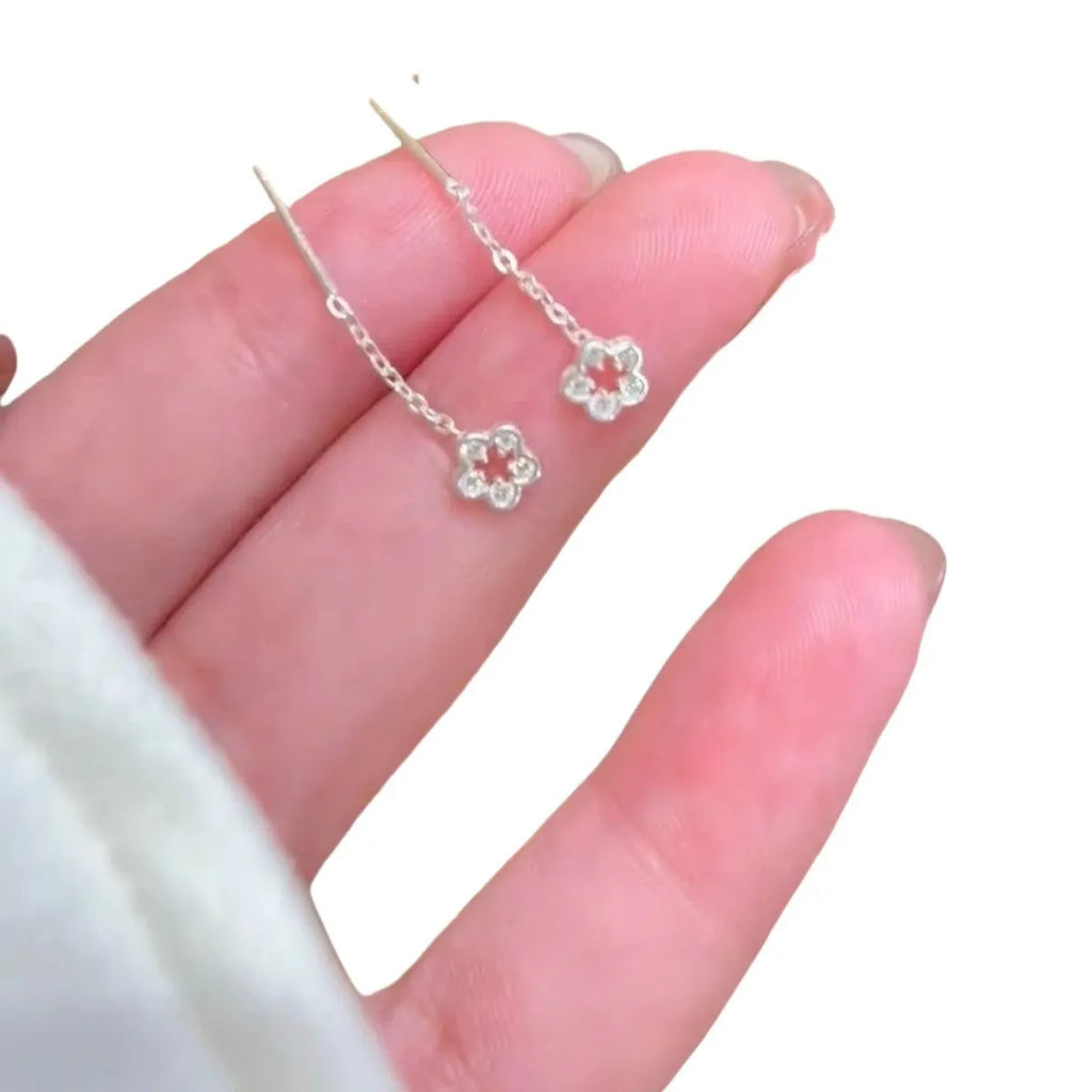 A pair of silver-coloured hollow flower stud earrings with petal details on sterling silver posts.