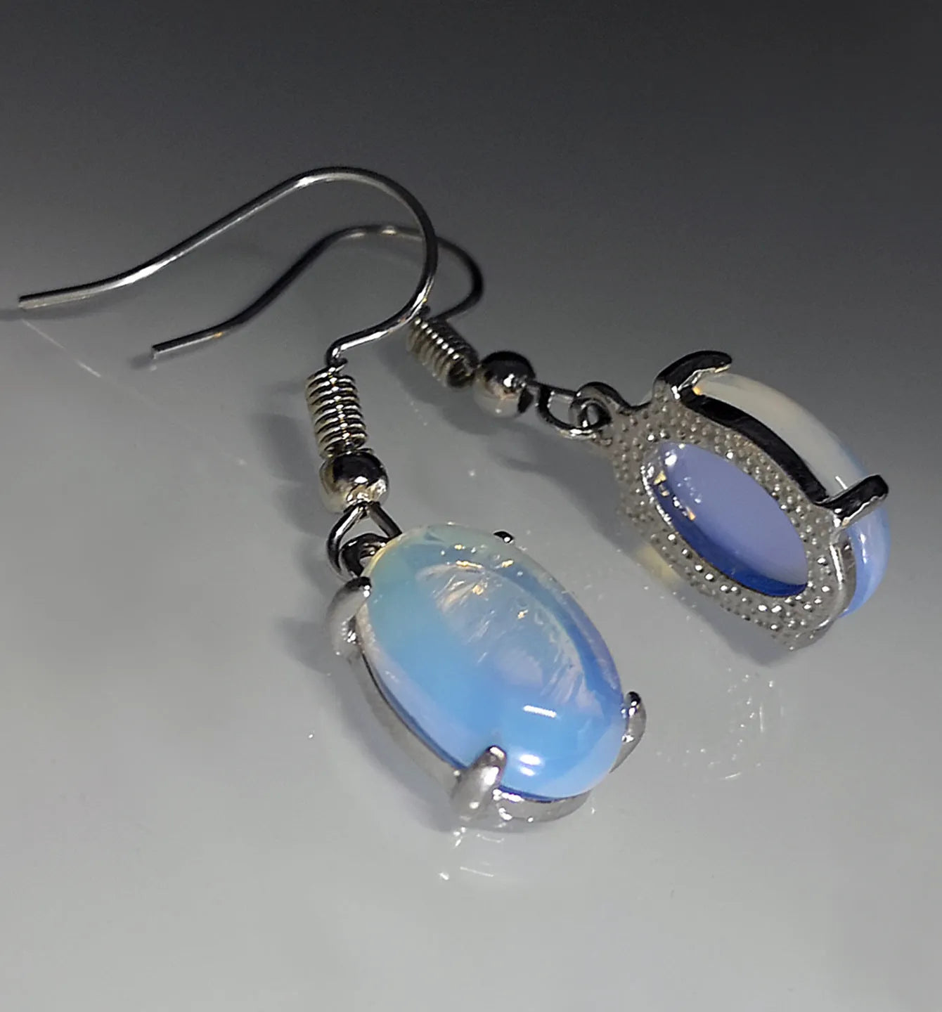 Pair of retro-style drop earrings with a moonlight opal colour and cross detail on an alloy base.