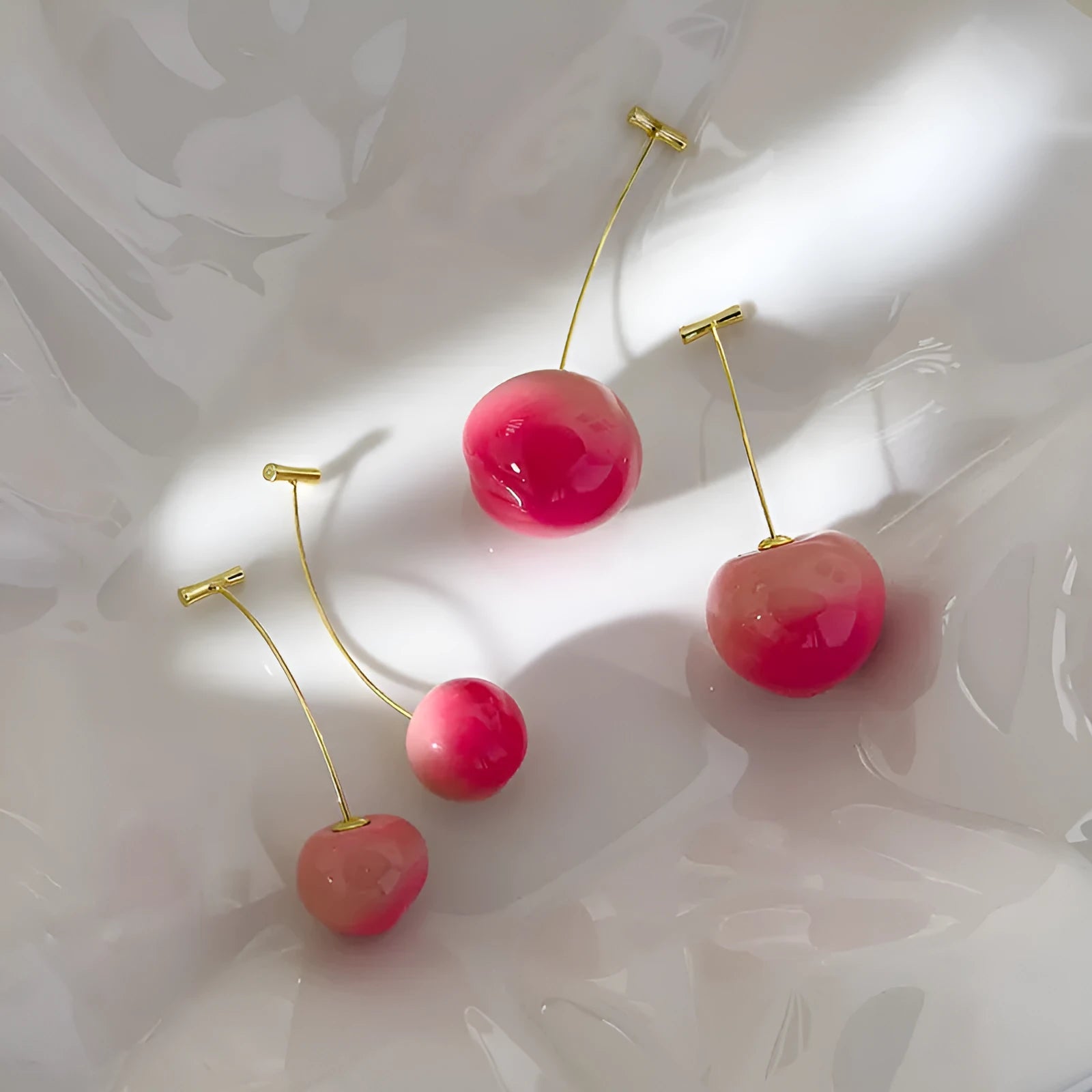 A pair of colourful acrylic peach-shaped earrings with copper posts, shown in small and large size options.