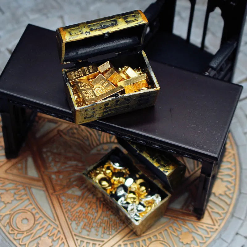 Miniature alloy gold coin and gold bar doll house accessory ornaments on display.