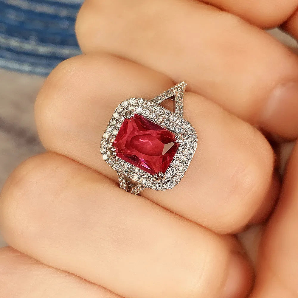 Copper square women's ring with a central red rhinestone on a hand model.