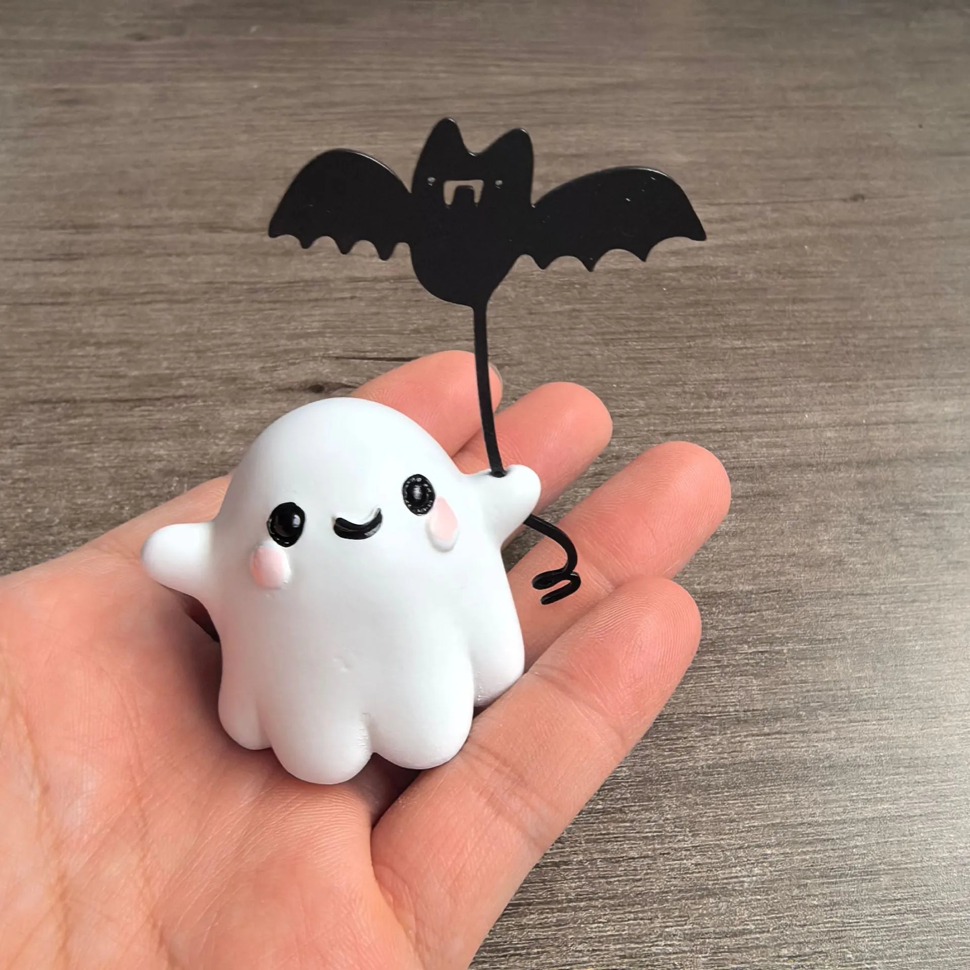 Miniature white ghost dog walking statue holding a small black bat, resin Halloween ornament