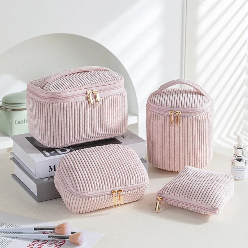 Set of four cube-shaped pink flannelette makeup bags with zips, one showing a removable interior divider and a metal hook.