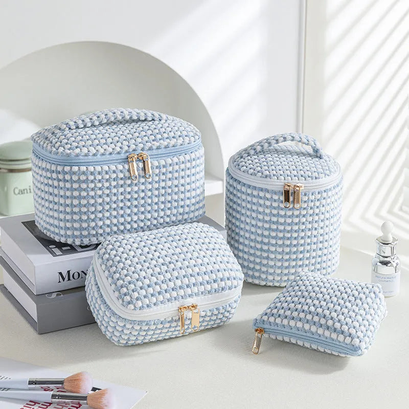 Set of four cube-shaped pink flannelette makeup bags with zips, one showing a removable interior divider and a metal hook.