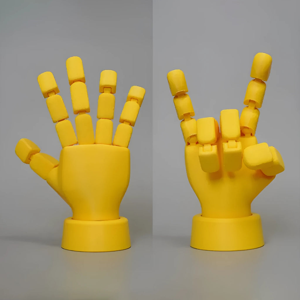 Yellow PLA movable joint hand prop ornament on a flat surface, showing articulated fingers.