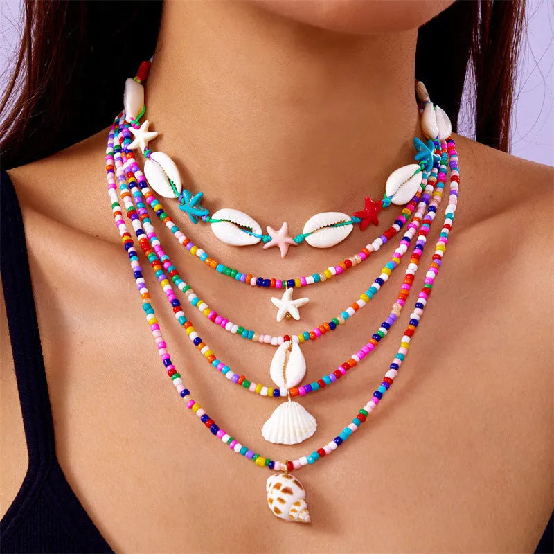 Five women's necklaces with shell and conch bead pendants on adjustable electroplated alloy chains