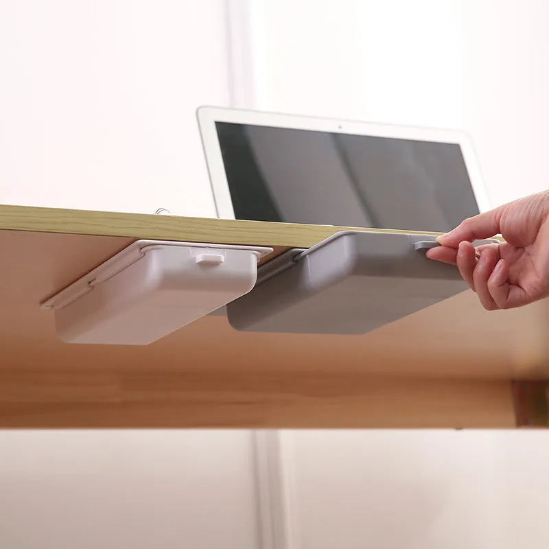 White plastic under-table storage drawer with magnetic adhesive backing and internal grid compartment