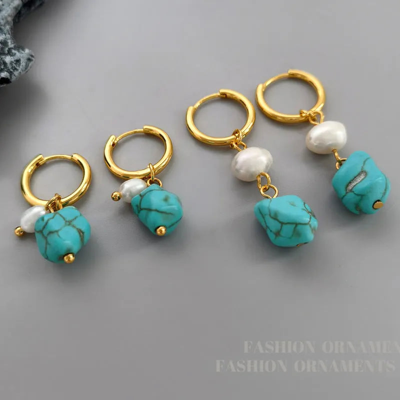 A pair of geometric copper earring clips with turquoise stones and cultured pearls, one short and one long.