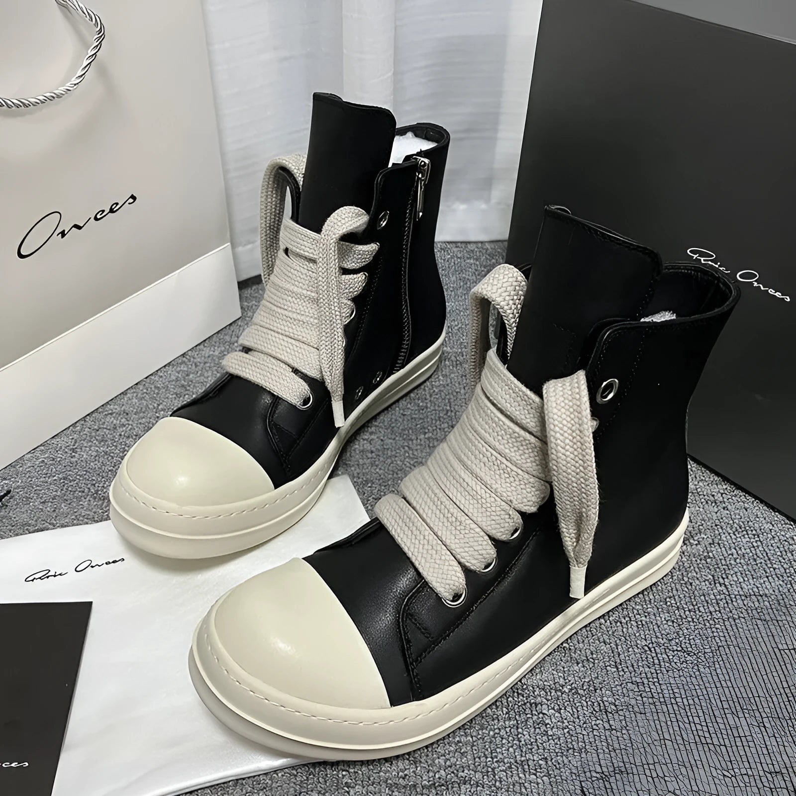 Black genuine leather high-top sneakers with a side zipper and round toe on a rubber sole.