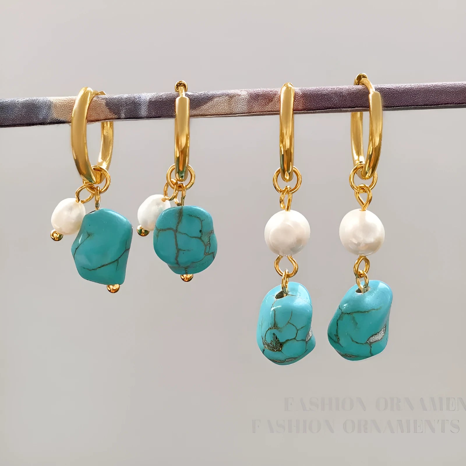 A pair of geometric copper earring clips with turquoise stones and cultured pearls, one short and one long.