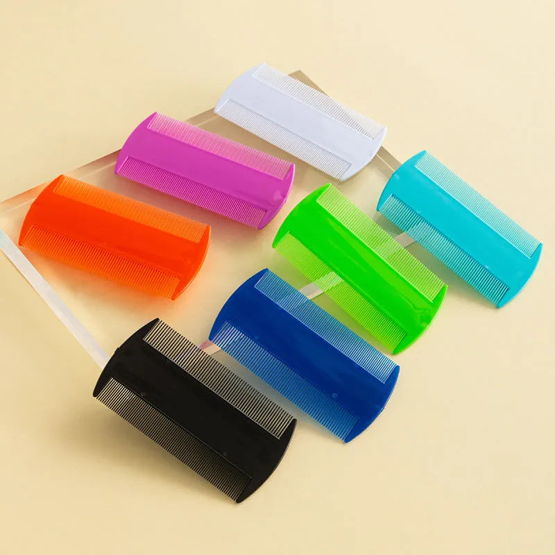 A white double-edged fine-toothed plastic lice comb on a blue surface, showing its 8cm length.