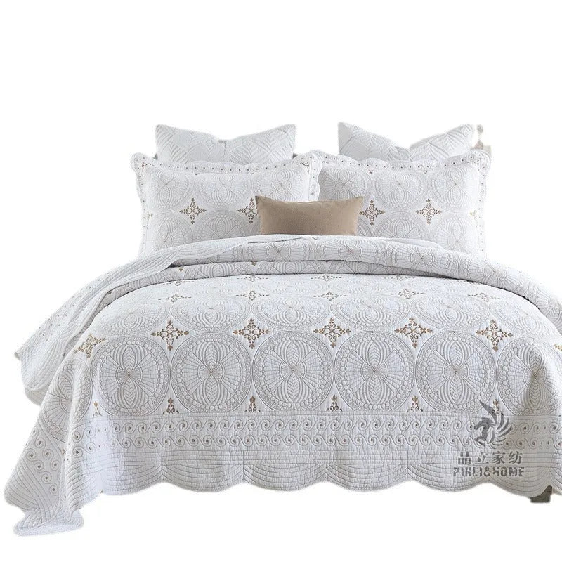 European-style embroidered pure cotton bed cover set with two pillowcases on a bed.