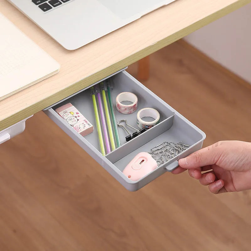 White plastic under-table storage drawer with magnetic adhesive backing and internal grid compartment