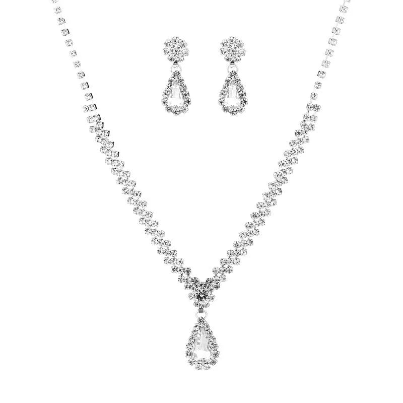 Women's blue claw chain necklace and drop rhinestone earrings set on white background.