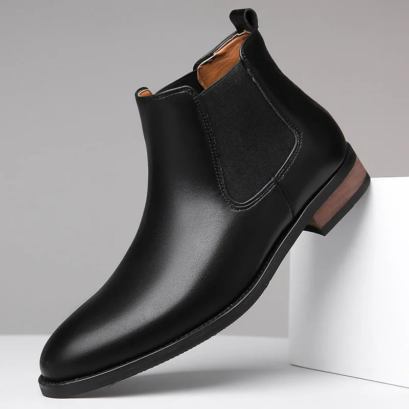 Men's black pointed-toe Chelsea boots with a low heel and rubber sole on a white background.